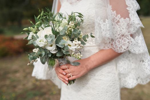 bride holding a bouquet of white roses in wedding day