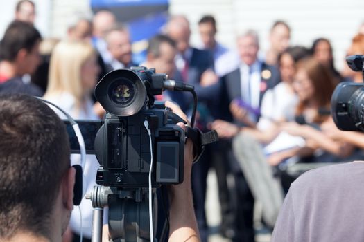 Filming an media event with a video camera. Press conference.