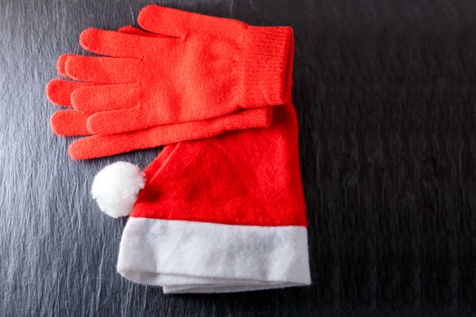 Santa's hat  and red gloves on black background