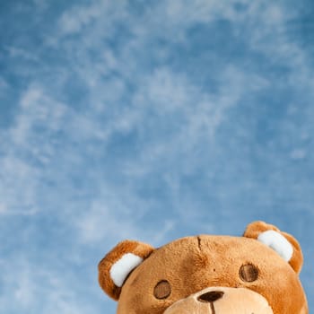 Teddy Bear toy on blue sky background with copyspace