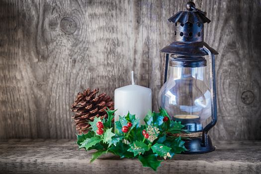 Christmas ornaments and candle light on rustic wood.