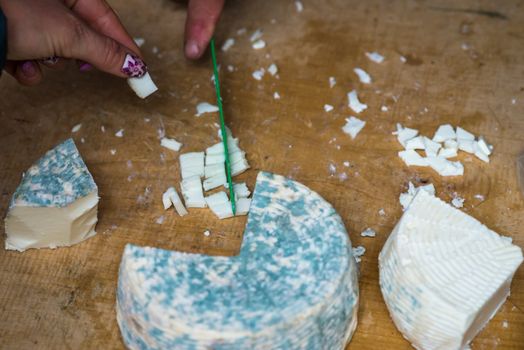 a pieces of cheese with blue mold is cut with a knife