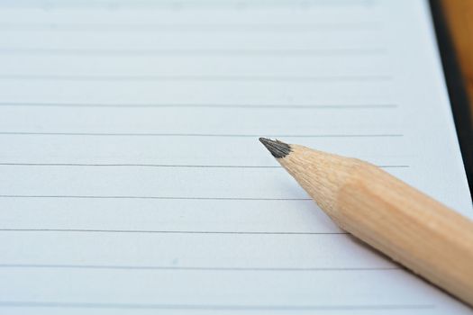 Closeup of a pencil on blank notebook