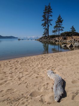 Scenic view of beautiful Lake Tahoe in Spring, landscape of the United States of America, clear water, nice sky, stone island, tree, fresh air and snow mountains