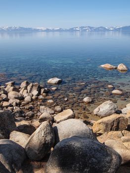 Scenic view of beautiful Lake Tahoe in Spring, landscape of the United States of America, clear water, nice sky, stone island, tree, fresh air and snow mountains