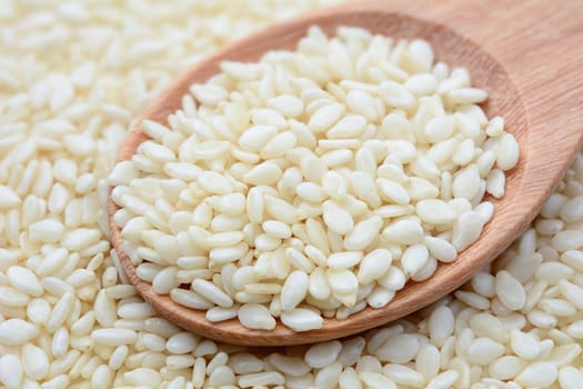 Closeup of white sesame seeds in wooden spoon