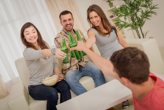 Friends enjoying with beer and cheers together at home party.