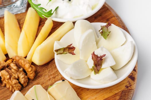 Assorted cheeses and wallnuts served at wooden board