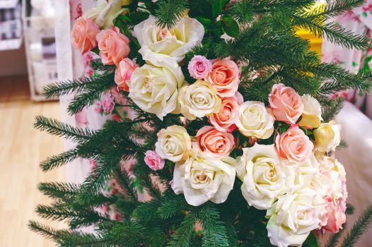 Green Christmas tree decorated with white and pink roses.