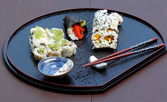 Different types of sushi on a serving plate.
