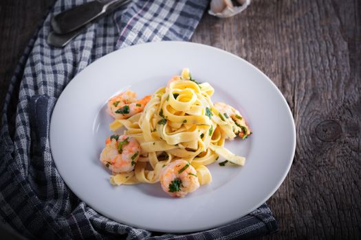 Tagliatelle with shrimps on a white plate