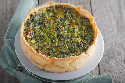 Spinach quiche - vegetable pie on a wooden surface.