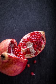 Ripe red Pomegranate on a stone plate.