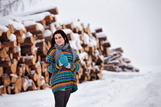 Beautiful young woman walking in winter outdoors. Wood logging