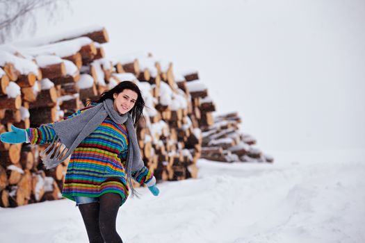 Beautiful young woman walking in winter outdoors. Wood logging