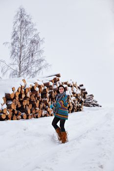 Beautiful young woman walking in winter outdoors. Wood logging