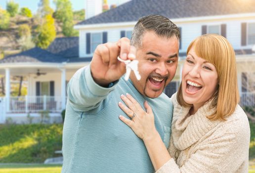Happy Mixed Race Couple in Front of New Home with House Keys.