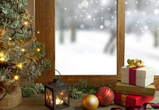 Christmas tree, gifts and decorations next to a window with snow scenery outdoors 