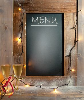 Champagne glasses next to menu board with space