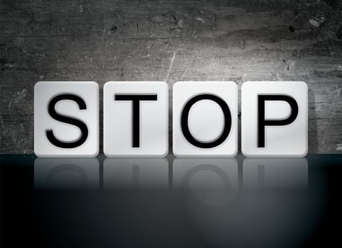 The word "Stop" written in white tiles against a dark vintage grunge background.