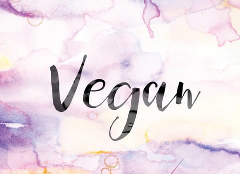 The word "Vegan" painted in black ink over a colorful watercolor washed background concept and theme.