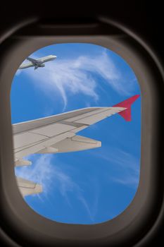 View from an airplane window on the wings and a beautiful blue sky with clouds.