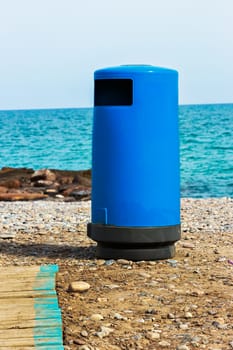 Blue beach trash with walkway. Vertical image.