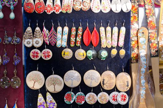 Many colorful handmade earrings for sale at outside street market fair