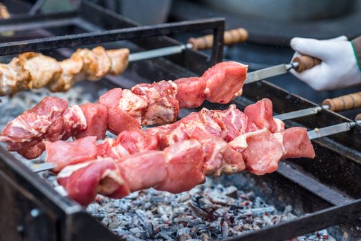 raw meat on skewers cooked on fire