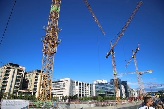 OSLO, NORWAY – AUGUST 17, 2016: A construction site of Bjorvika under construction in progress with a heavy vehicle and cranes in Oslo, Norway on August 17,2016.