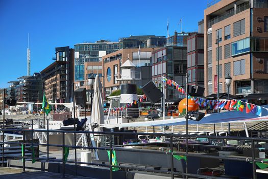 OSLO, NORWAY – AUGUST 17, 2016: People walking on modern district on street Stranden, Aker Brygge district with lux apartments, shopping, culture and restaurants in Oslo, Norway on August 17,2016.