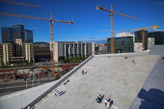 OSLO, NORWAY – AUGUST 17, 2016: View on Bjorvika and tourist on the Oslo Opera House which is home of Norwegian National Opera and National Opera Theatre in Oslo, Norway on August 17,2016.