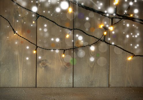 Christmas decorative lights on a wooden background with space