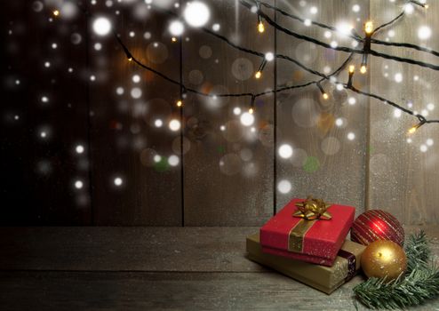 Christmas gifts and decorative lights on a wooden background with space