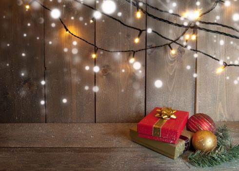 Christmas gifts and decorative lights on a wooden background with space