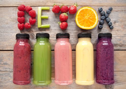 Assorted flavoured smoothie juices in bottles with detox spelt using fruits and vegetables 