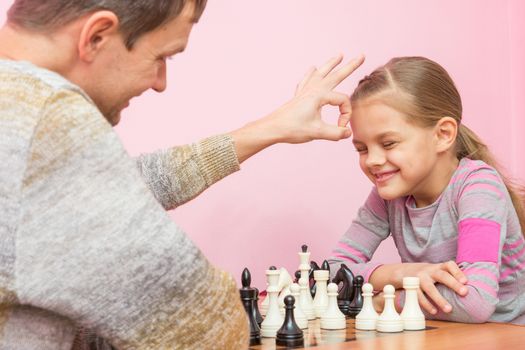 Dad won a game of chess at a daughter on a bet and hit her on the head