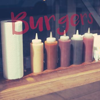 A Sign And Row Of Sauces In The Window Of A Hipster Style Burger Restaurant