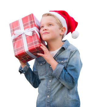 Curious Young Boy Wearing Santa Hat Holding Christmas Gift Isolated on a White Background.