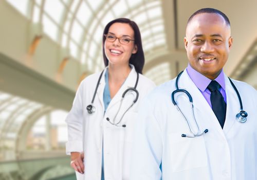 Female and Male Caucasian and African American Doctors in Hospital Office.