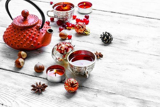 Kettle,cranberry tea and Christmas toy on light background