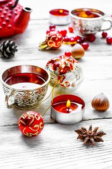 Kettle,cranberry tea and Christmas toy on light background