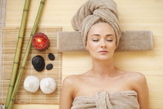 Beautiful young woman relaxing in spa salon