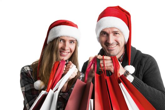 Couple in Santa hats with christmas shopping bags isolated on white background