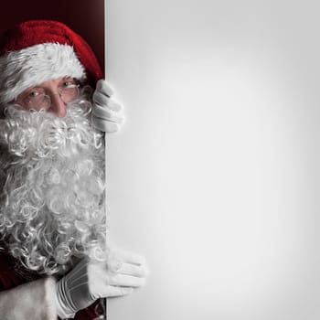 Santa Claus holding big blank paper card with copy space