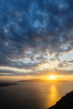 Dramatic sunset over Santorini caldera sea with volcano island