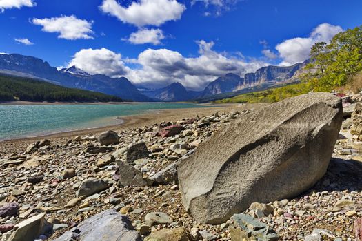 Boulder on the shore highlights wild beauty of Lake Sherburne in Glacier National Park, Montana, USA.  Pure water is a reservoir in Many Glaciers region.