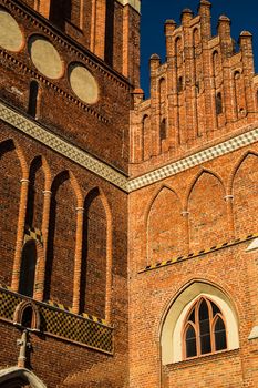 Gothic renovated cathedral St. John Church in Gdansk, Poland. Facade with white clouds on blue sky photography.