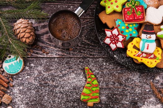 Different ginger cookies and coffee for new years and christmas on wooden background, xmas theme. Top view.