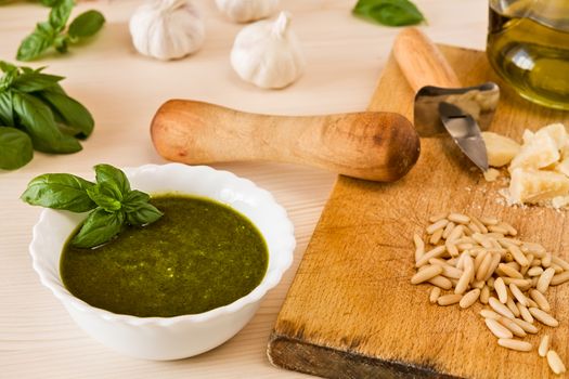 Closeup of pesto genovese with its ingredients over a table